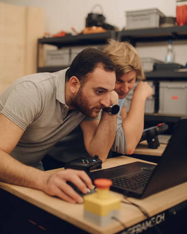 Karim Fawaz und Saro Tschan planen eine Roboterfahrt am Laptop